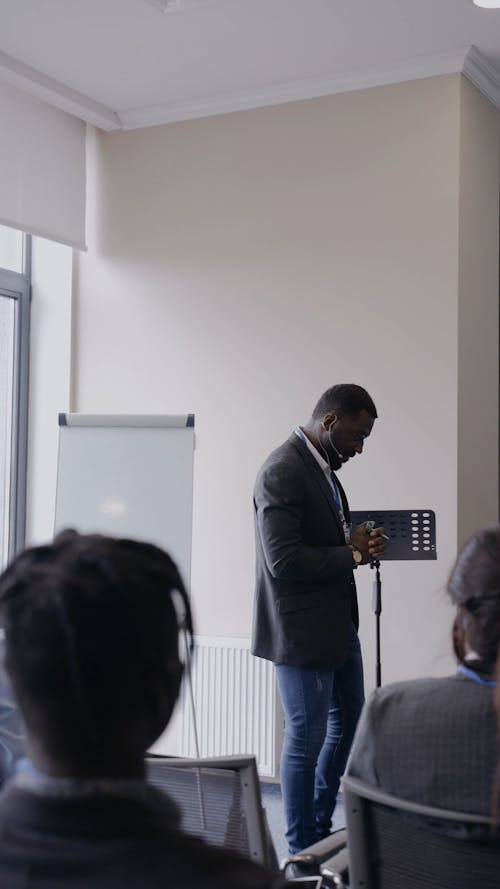 A Man Discussing a Presentation to Business People