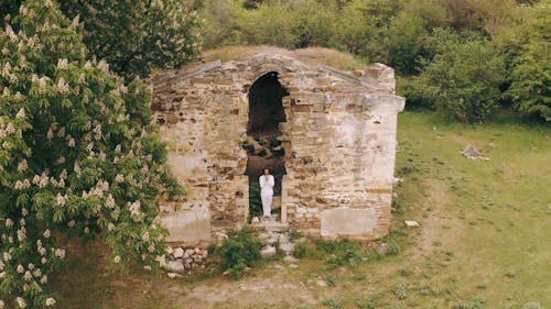 A Man Standing at the Entrance of an Abandoned Building