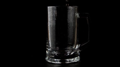Pouring Alcoholic Beverage in a Transparent Cup