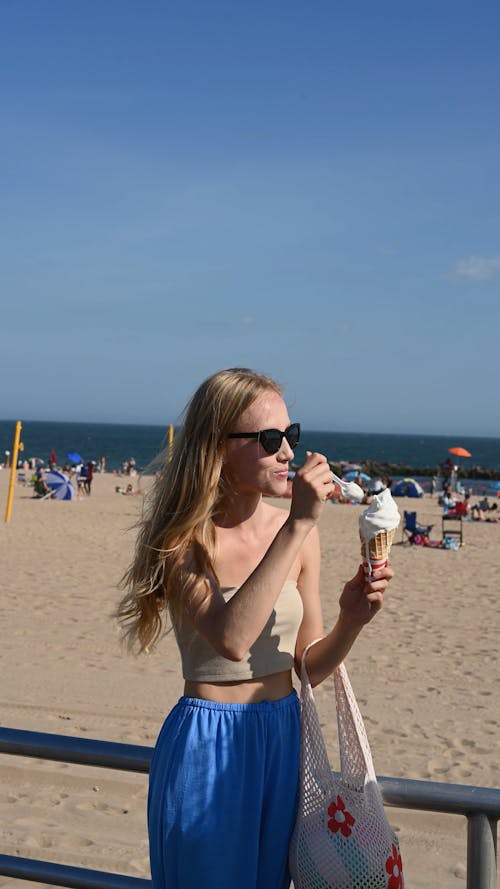 Woman Eating Ice Cream on a Beach