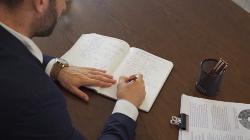 Person Writing on Notebook
