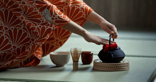 A Woman Pouring Hot Water into Cup