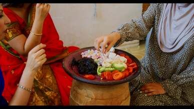 close up footage of people eating sliced fruits and vegetables on a plate