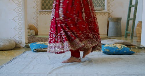 A Barefooted Person Wearing Read Dress Spinning Around