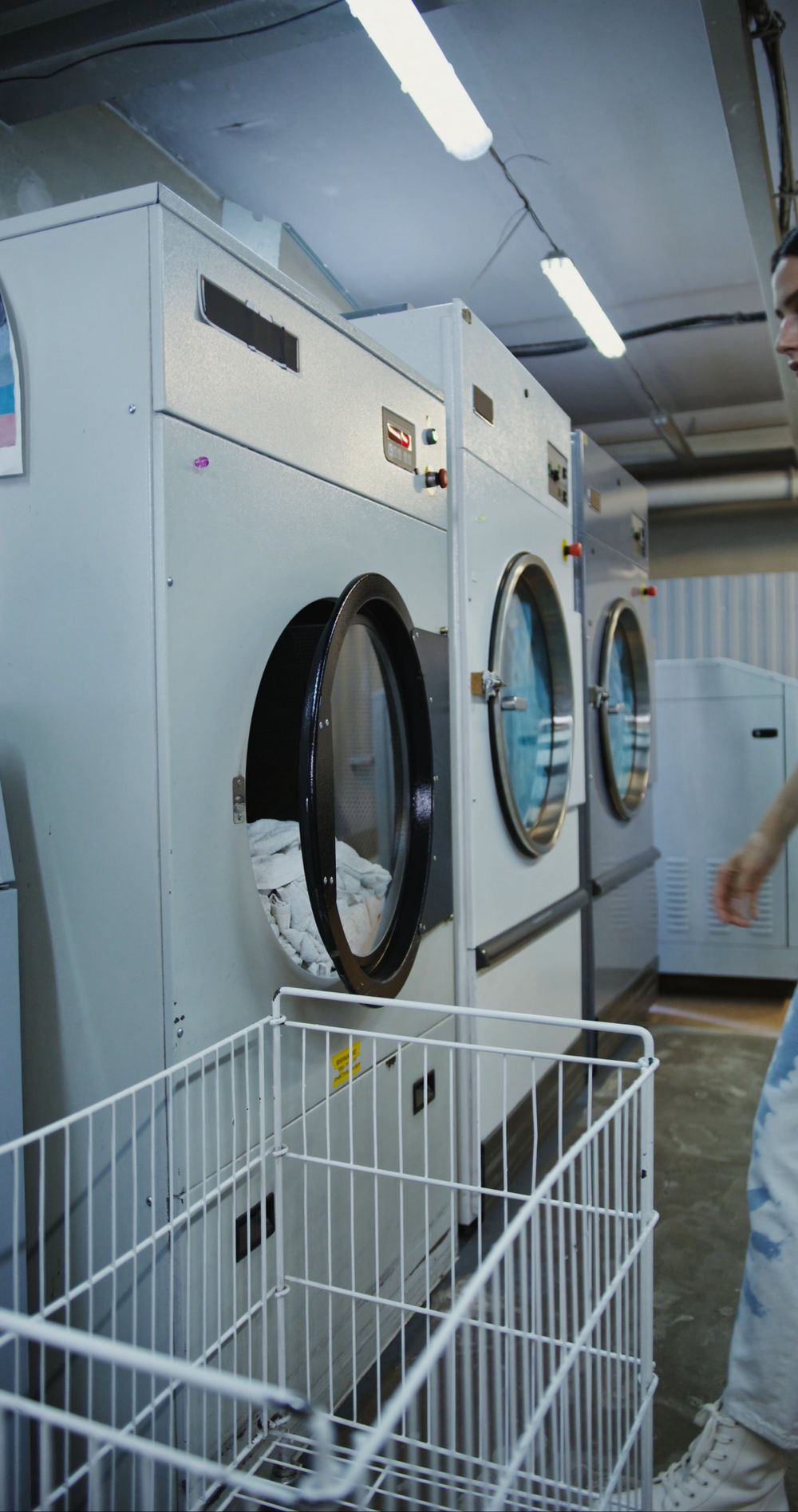 Laundry worker loading a front-load washing machine