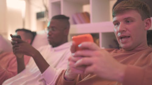 Men Sitting on a Couch While Using Cellphone