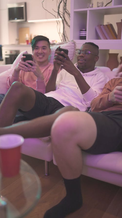 Men Sitting on Sofa Using Cellphones