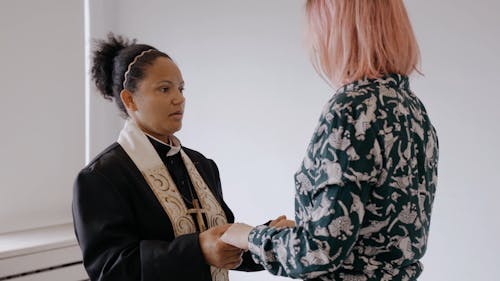 A Woman Pastor Holding a Parishioners Hands