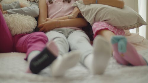 Young Girls Sitting Together on a Bed