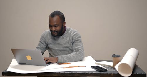 A Man Typing on Laptop