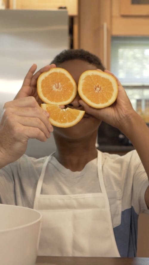 Person Covering His Face with Oranges