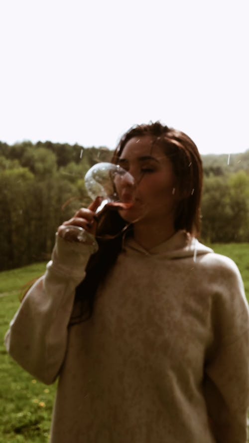 A Woman Drinking Wine in the Rain
