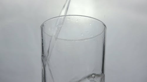 Pouring Water on a Glass Cup