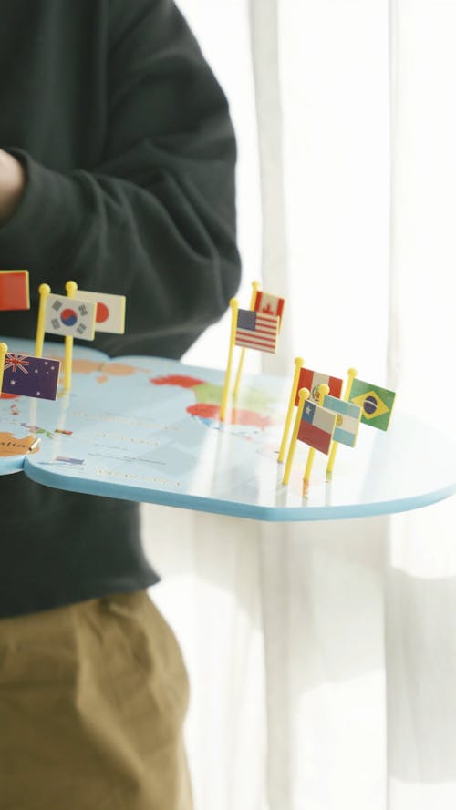Man Putting Flags on a World Map
