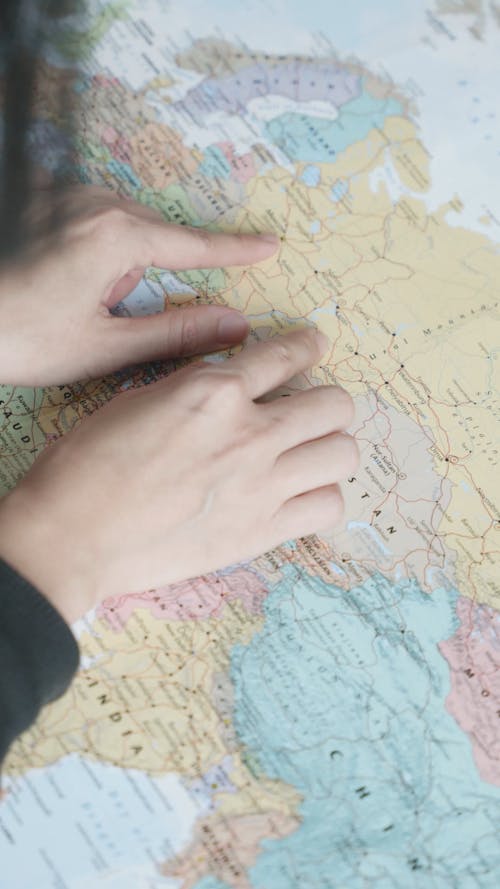 Person Pointing at Places in a World Map