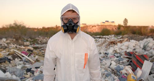 Man Wearing Personal Protective Equipment Walking While Looking at the Camera 
