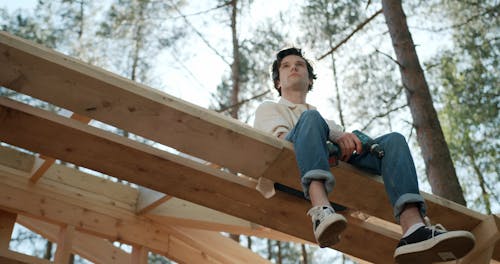 A Man Sitting while Holding a Drill