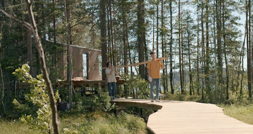 Men Walking while Carrying Wood Plank