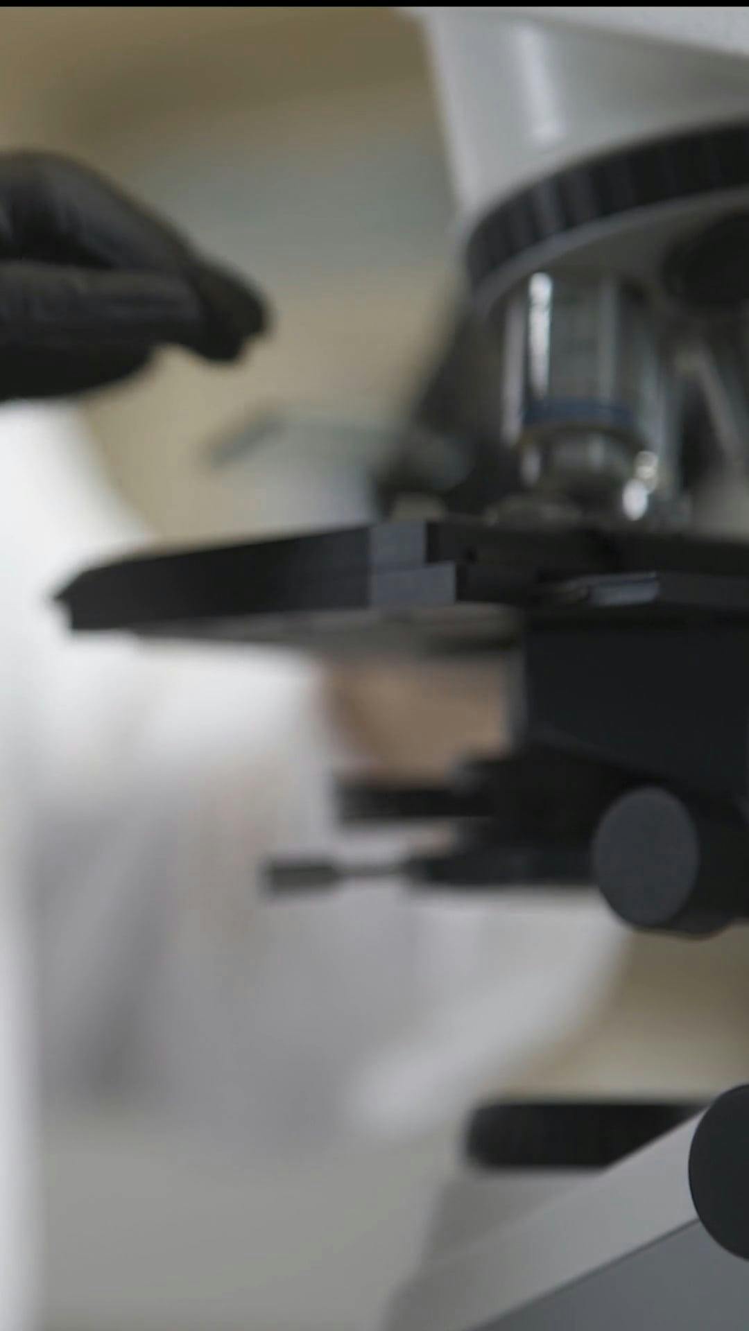 A Person Putting Microscope Slide on a Microscope · Free Stock Video