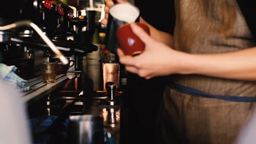 A Person Pouring Milk into a Cup