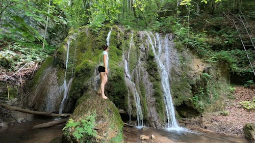 A Woman Standing on a Boulder of Rock 