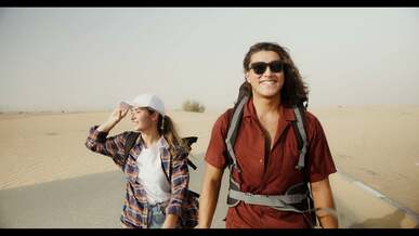 a man and woman talking while walking on the road