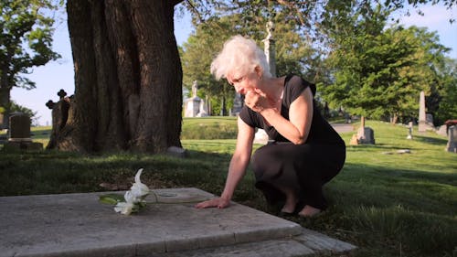 A Woman Crying In Front of a Tombstone