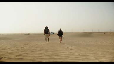 a couple in a desert walking toward their car