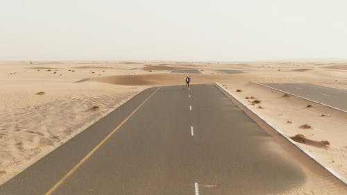 A Drone Footage of a Woman Walking on the Road