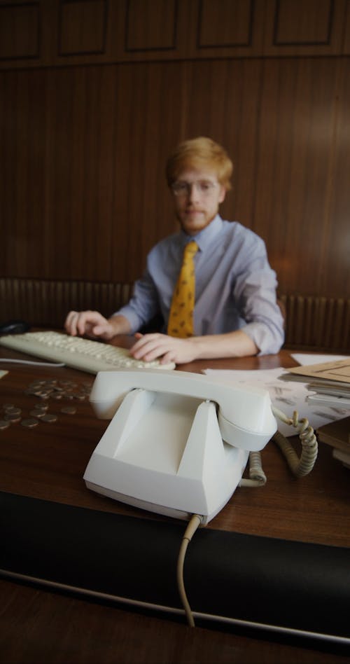 A Man Answering the Telephone at an Office