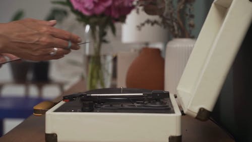 A Person Putting Vinyl Record on a Turntable