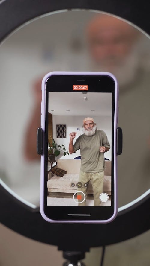 A Smartphone Recording a Video of a Dancing Elderly Man