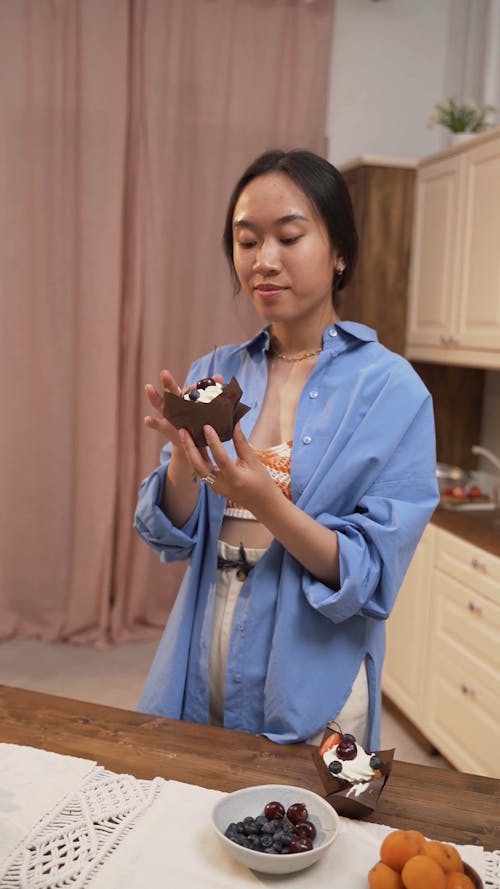 A Smiling Woman Eating a Cupcake