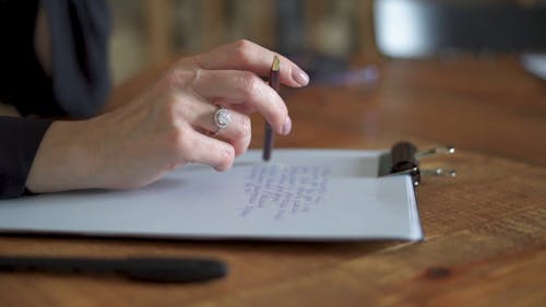 Close up of a Person Writing on Paper