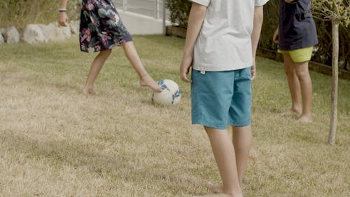 Children Playing Soccer on the Grass Field 