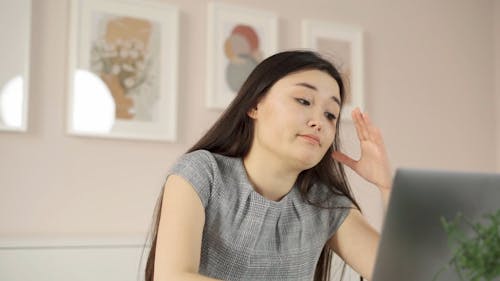A Stressed Woman Shaking her Head at her Work Desk