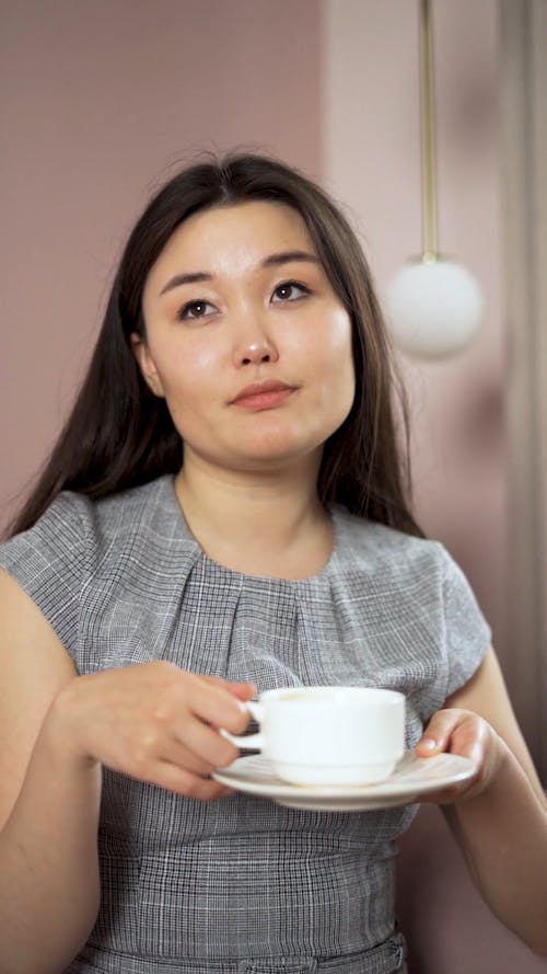 A Businesswoman Drinking Coffee while Sitting on a Couch