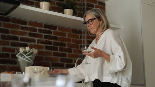 An Elderly Woman Holding Glasses