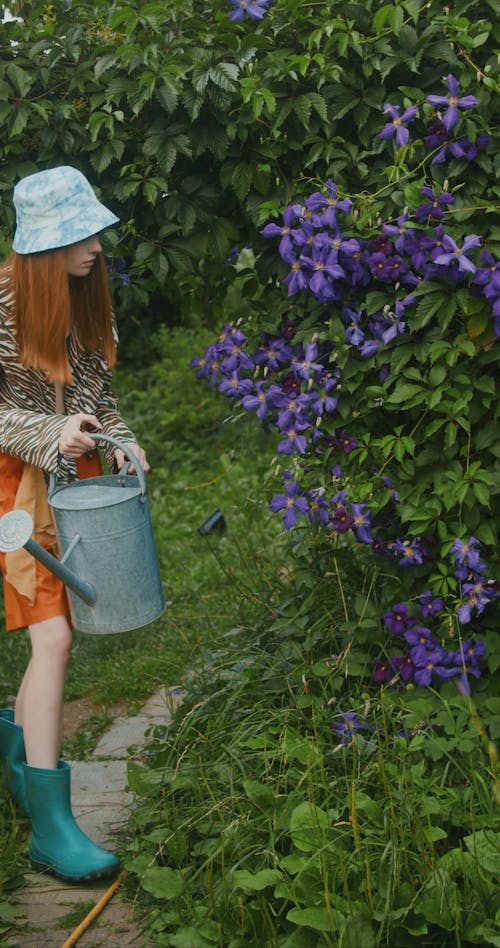 A Woman Holding a Watering Can in a Garden