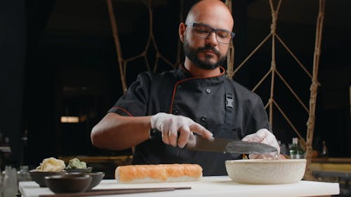 A Man Slicing Sushi Roll