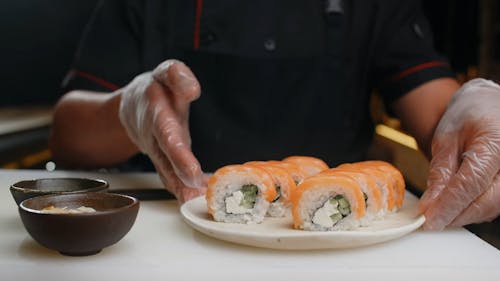 A Person Holding a Plate of Sashimi
