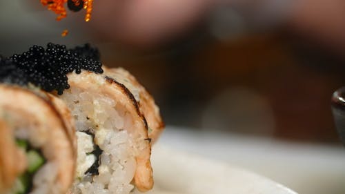 Roe Being Placed on Top of Seared Sushi