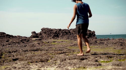 Man Walking Barefoot in the Beach Shore