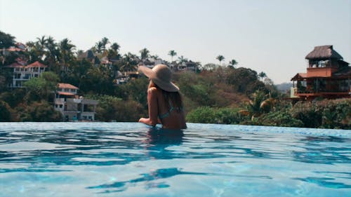 A Woman Looking at the View from a Swimming Pool