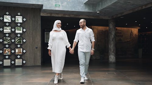 A Couple Holding Hands While Walking