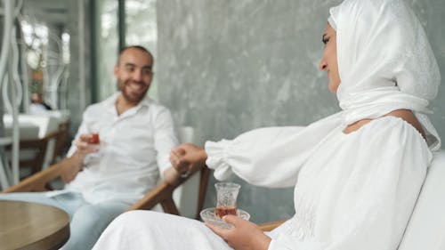 Woman Wearing Hijab Holding the Hand of a Man