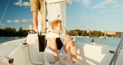 A Boy Sitting on a Sailing Boat