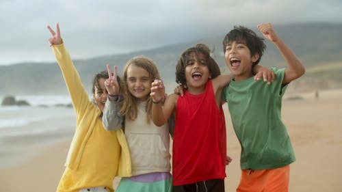 Happy Children Posing Together on a Windy Day at the Beach 