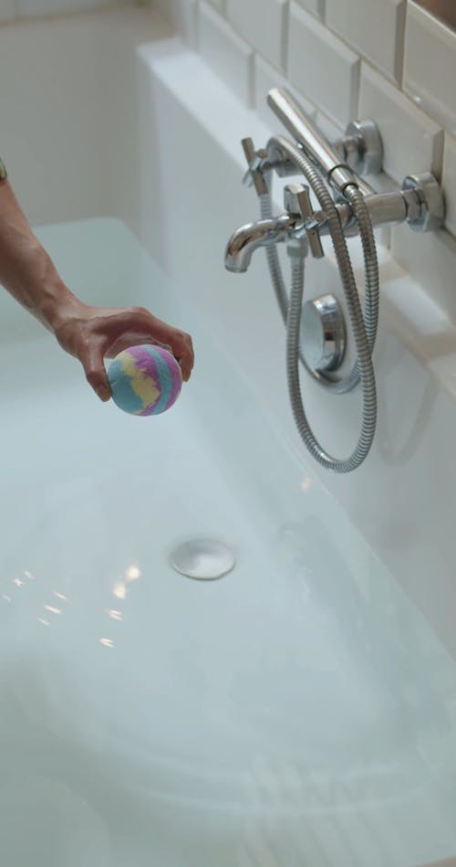 Person Putting Bath Bomb on the Bathtub