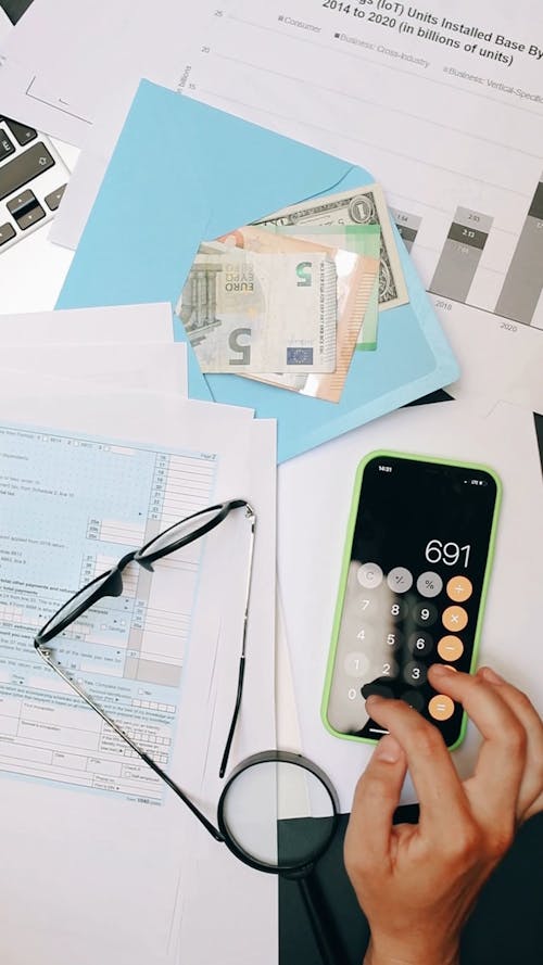 Person Using Calculator on Smartphone 